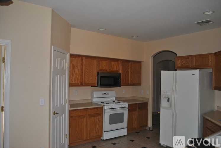 A kitchen with white appliances and wooden cabinets.