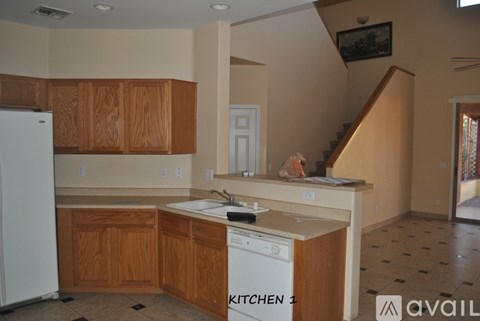 A kitchen with wooden cabinets and a white dishwasher.