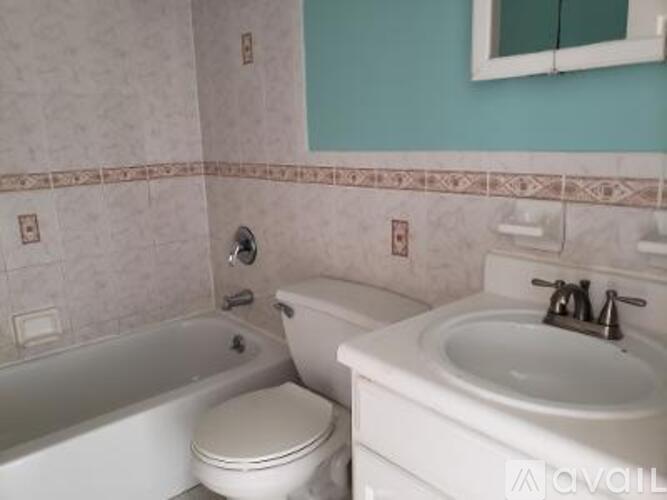 A white toilet sits next to a white sink in a bathroom.