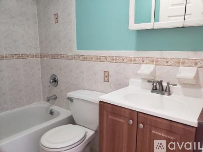 A white toilet sits next to a bathtub in a bathroom.
