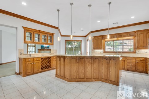 A large, well-lit kitchen with wooden cabinets and a central island.