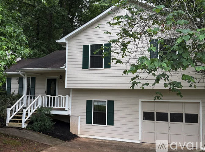 A house with a white garage door and green shutters.