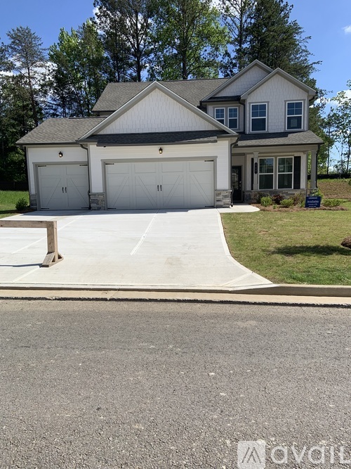 A two-story house with a garage and a driveway.