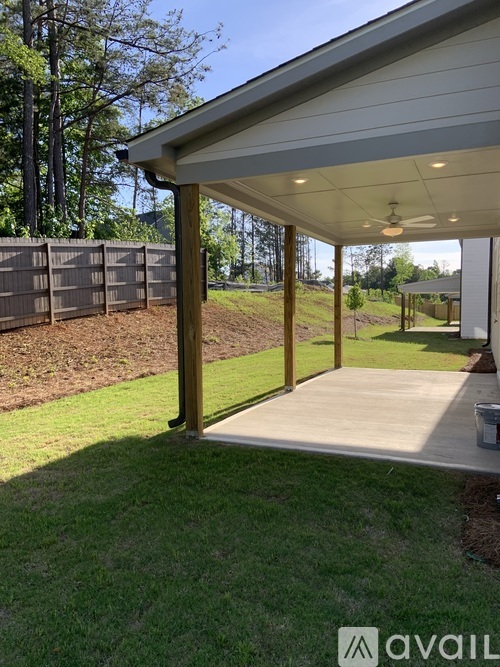 A covered outdoor area with a wooden fence in the background.