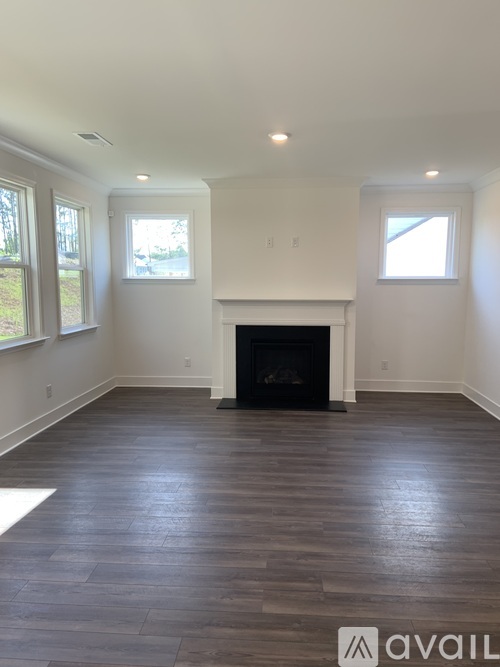 A living room with a fireplace and wood flooring.