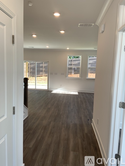 A room with wooden flooring and white walls.