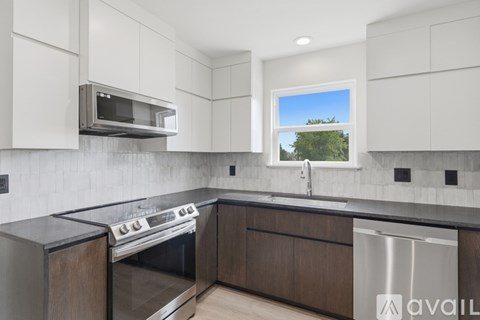 A modern kitchen with a stainless steel oven and microwave above a stove.