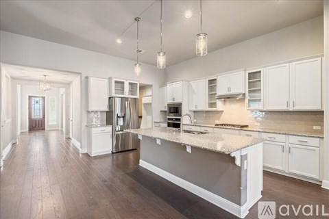 A modern kitchen with white cabinets and a central island.