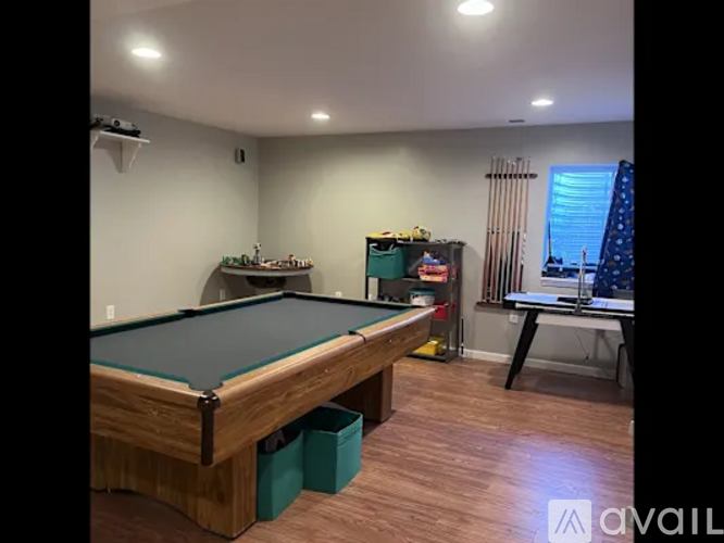 A pool table in a room with a green cloth on it.