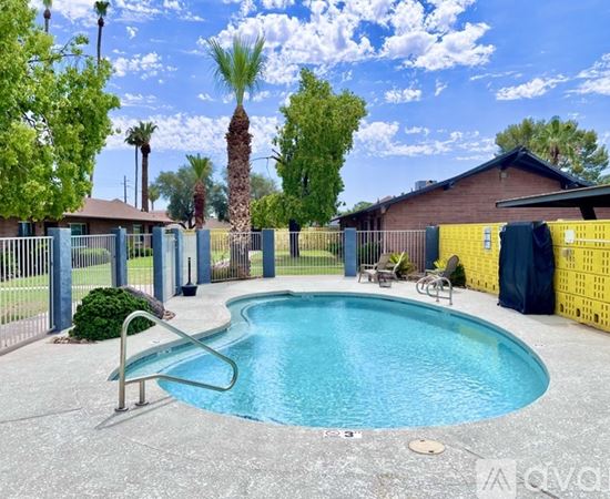 A pool surrounded by a fence and trees.