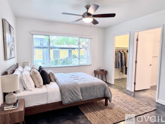 A bedroom with a large bed and a ceiling fan.