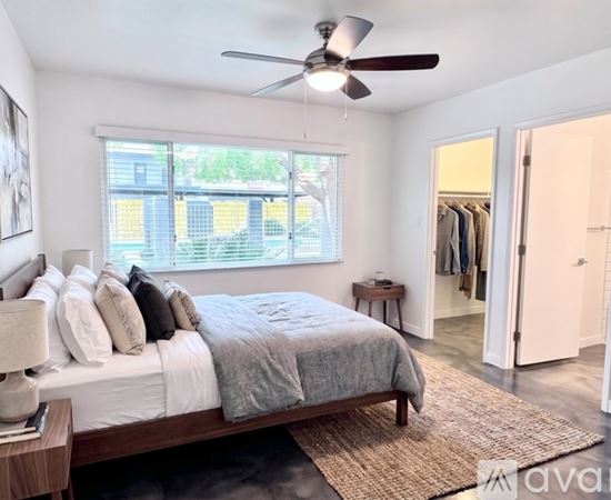 A bedroom with a large bed and a ceiling fan.