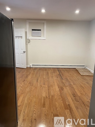 A room with wooden flooring and a white door.