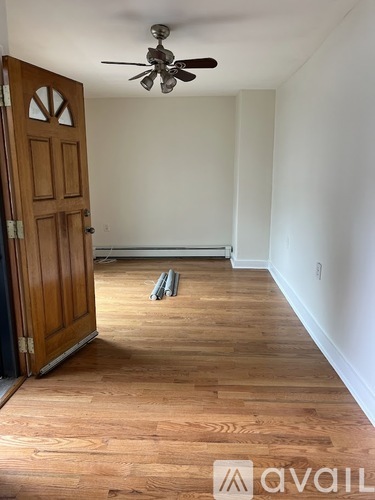 A room with a wooden floor and a ceiling fan.
