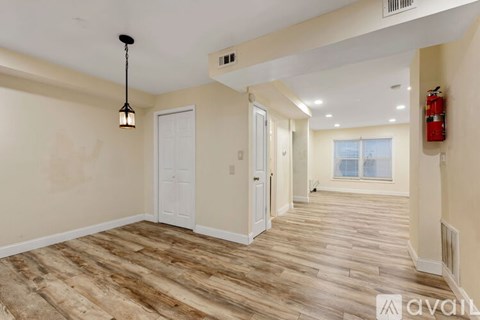 A room with wooden flooring and a white door.