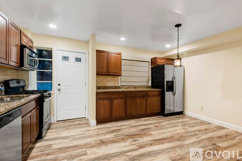 A kitchen with wooden cabinets and a white door.