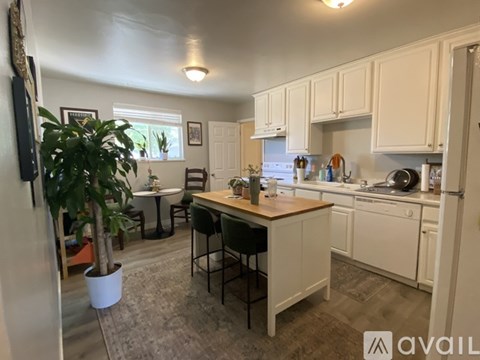 A kitchen with white cabinets and a wooden island.