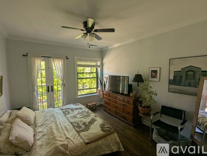 A bedroom with a bed, dresser, chair, and window.