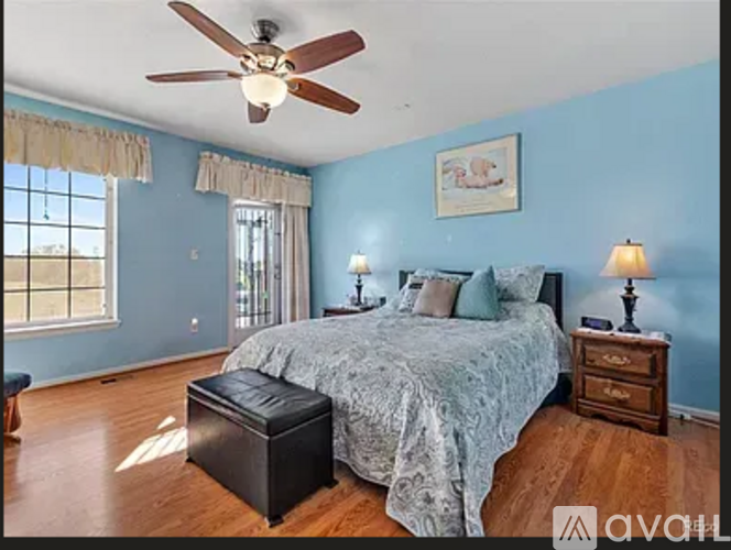 A bedroom with a bed, two lamps, and a ceiling fan.