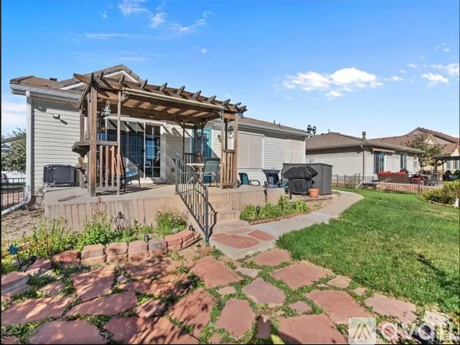 A house with a patio and a stone pathway leading to it.