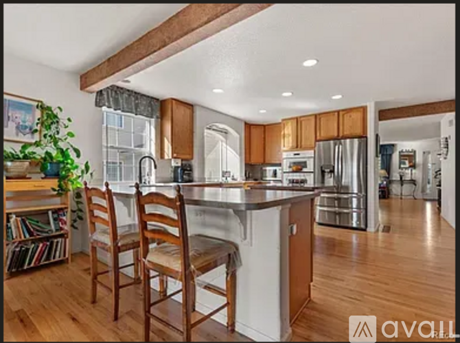 A kitchen with wooden floors and a white countertop.