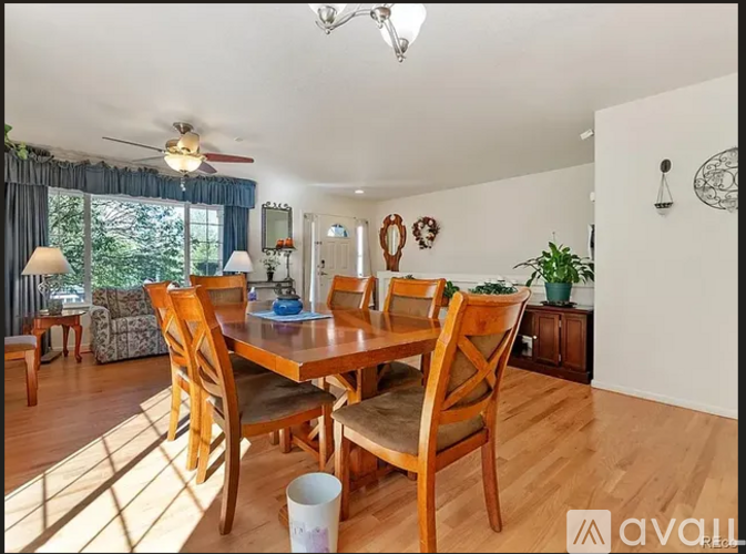 A dining room with a wooden table and chairs.