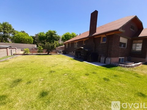 A house with a red roof and a large lawn in front.