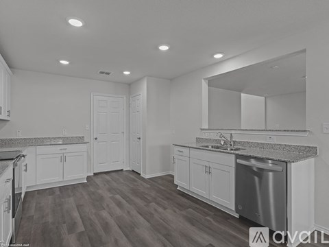 A kitchen with white cabinets and a granite countertop.