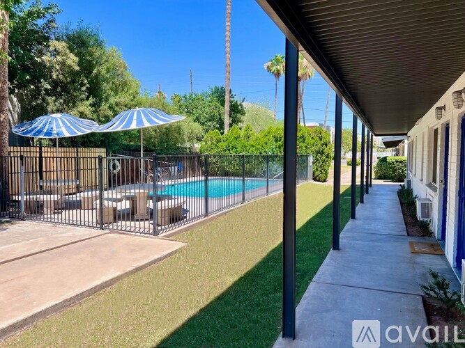 A pool area with a fence and umbrellas.