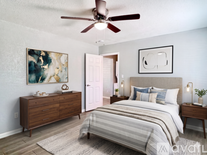 A bedroom with a bed, dresser, and ceiling fan.