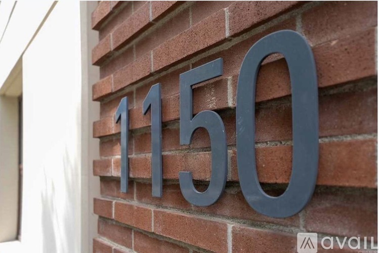 A house number sign on a brick wall.