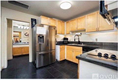 A kitchen with wooden cabinets and a black countertop.