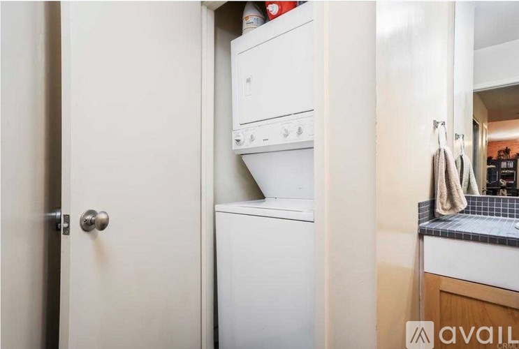 A white dishwasher is in a kitchen next to a white door.