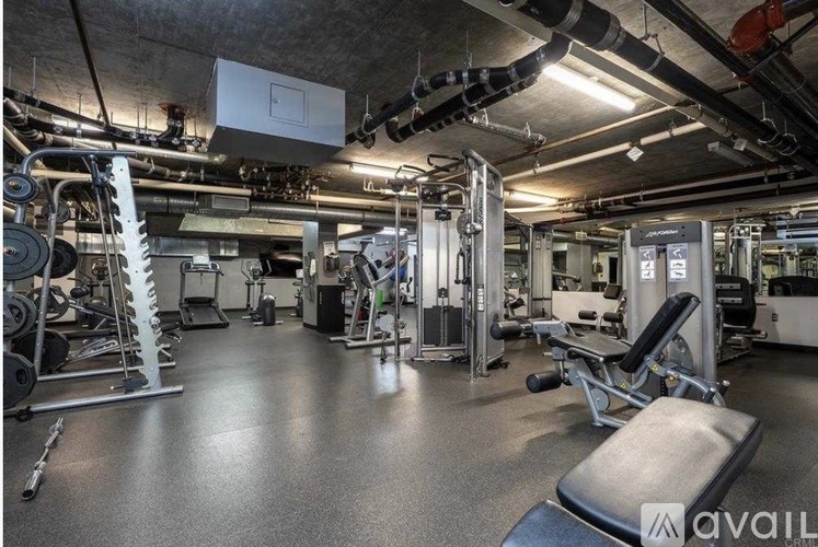 A gym with a variety of equipment including weights and machines.