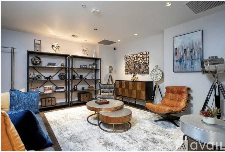 A living room with a sofa, a coffee table, and a shelf with various items.