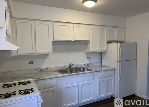 A kitchen with white cabinets and a stove top oven.