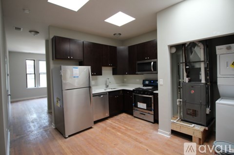 A kitchen with a stainless steel refrigerator and wooden floors.