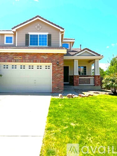 A two-story house with a garage and a brick exterior.