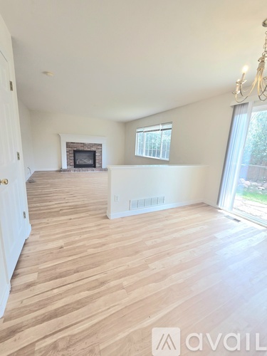A living room with a fireplace and wooden flooring.
