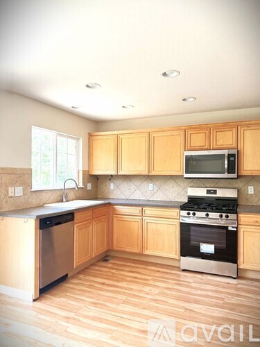 A kitchen with wooden cabinets and stainless steel appliances.