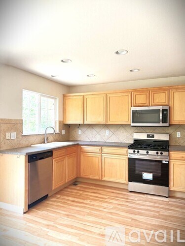 A kitchen with wooden cabinets and stainless steel appliances.