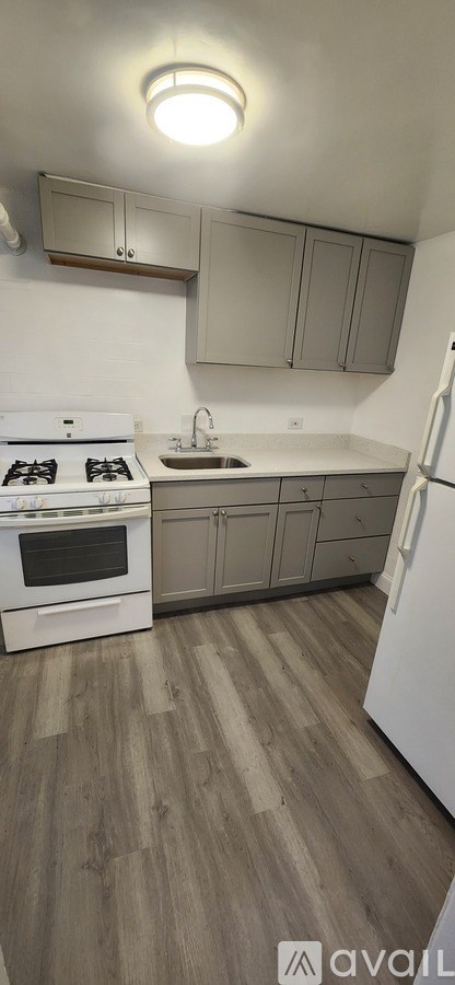 A kitchen with a white stove top oven and a white refrigerator.