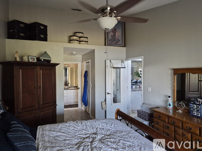 A bedroom with a bed, dresser, and ceiling fan.