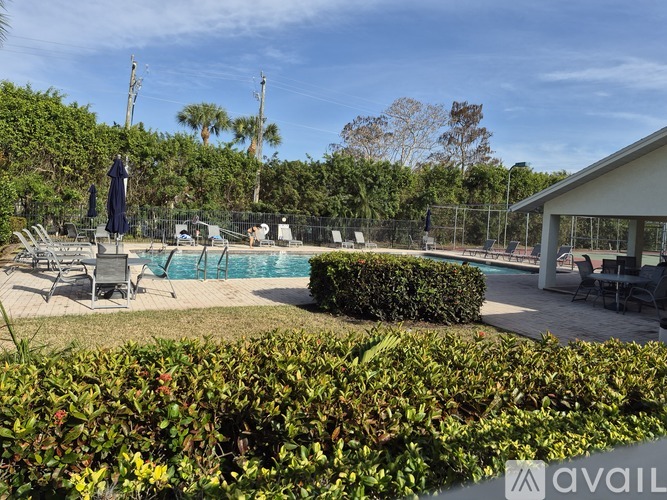 A pool area with a statue and a building in the background.