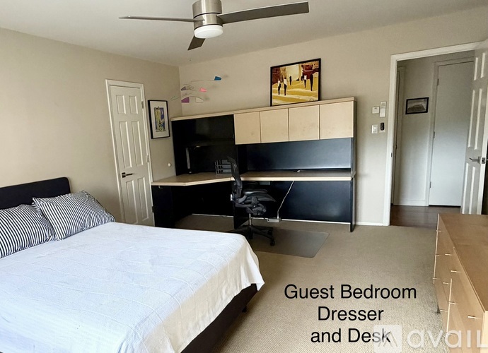 A guest bedroom with a dresser and desk.