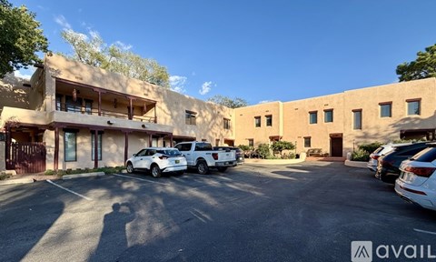 A parking lot with cars and a building in the background.
