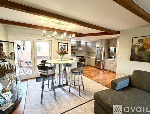 A modern kitchen with a dining table and chairs in the foreground.