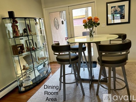 A dining room area with a glass display cabinet and a round table with four chairs.
