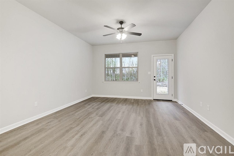 A room with a ceiling fan and a door leading outside.