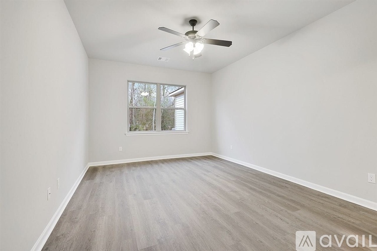 A room with a ceiling fan and a window.